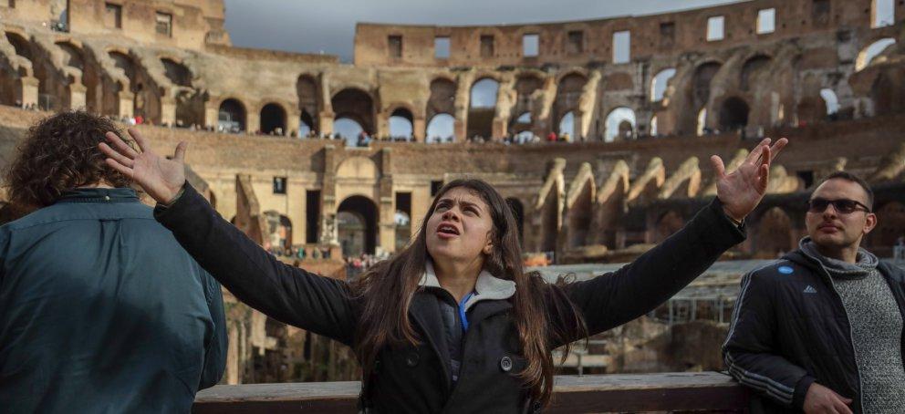Student holding her arms up inside the roman colosseum