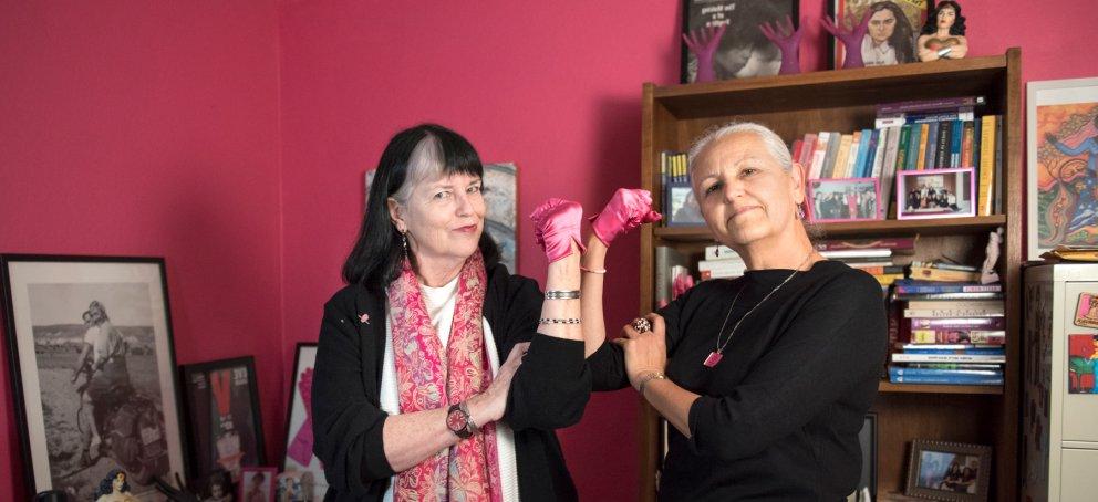 Two women's and gender studies professors holding up their fists to show power